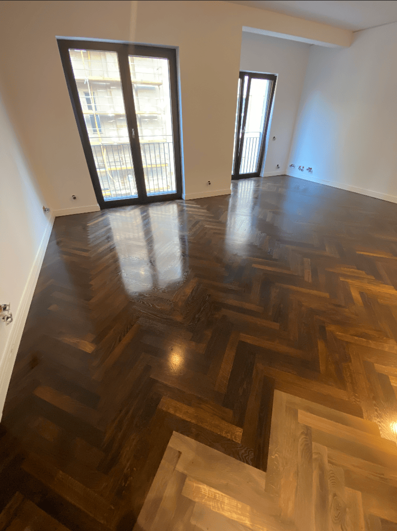 Dunkles Parkett im Fischgrätmuster.